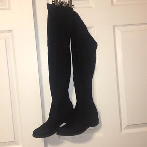 Knee high black suede boots.